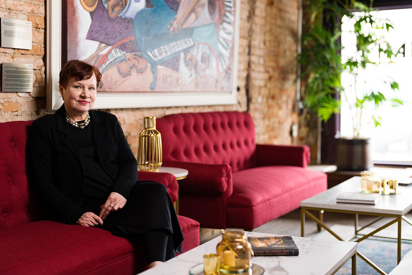 A woman sitting in a red couch in a lounge